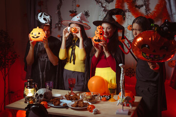 Asian man and woman celebrating Halloween, pumpkins at night, Halloween banner background for holiday activities.
