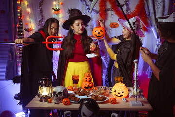 Asian man and woman celebrating Halloween, pumpkins at night, Halloween banner background for holiday activities.