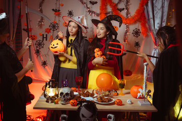Asian man and woman celebrating Halloween, pumpkins at night, Halloween banner background for holiday activities.