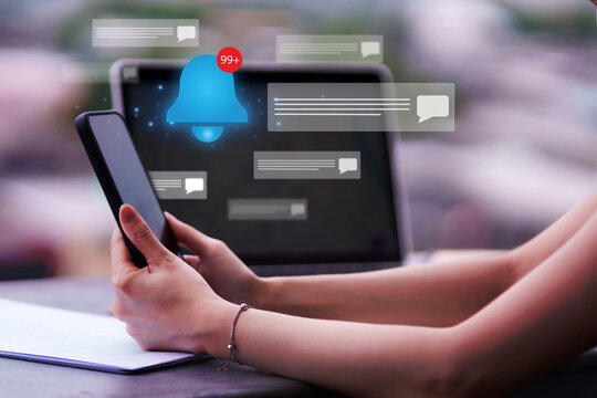Person uses smartphone device laptop screen with numerous digital notifications. Professional manages busy online communication social media content technology alerts digital overload.