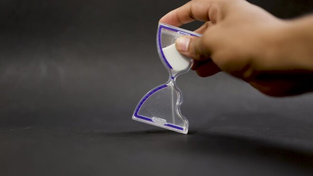 hand resetting sand clock measuring minutes concept of time and work management