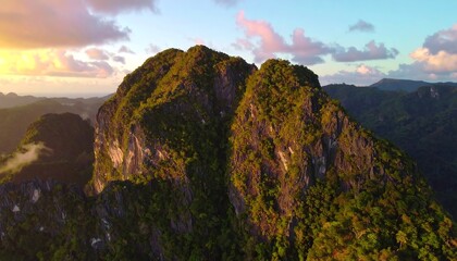 Golden sunset light on a rugged, jungle-clad peak