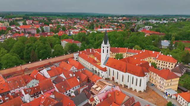 aerial top view flight over the historical town of Třeboň Wittingau in South Bohemia, Czech Republic, showcasing its picturesque red-roofed buildings, the prominent Třeboň Castle, and surrounding lush