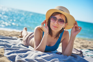 Portrait of woman relaxing on sand on tropical bach.