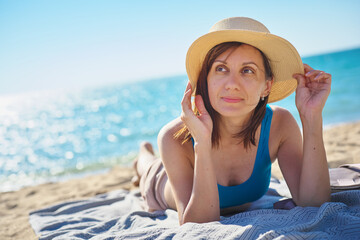 Portrait of woman relaxing on sand on tropical bach.