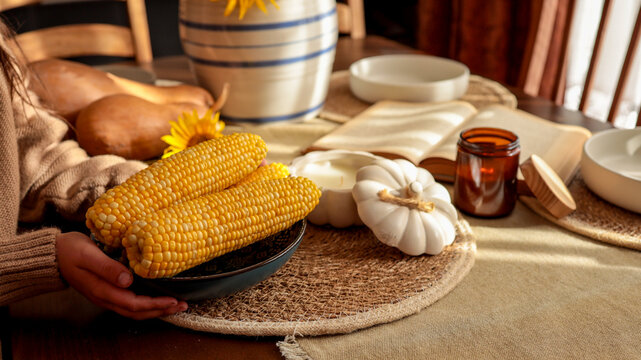 Autumnal table setting with corn and pumpkins