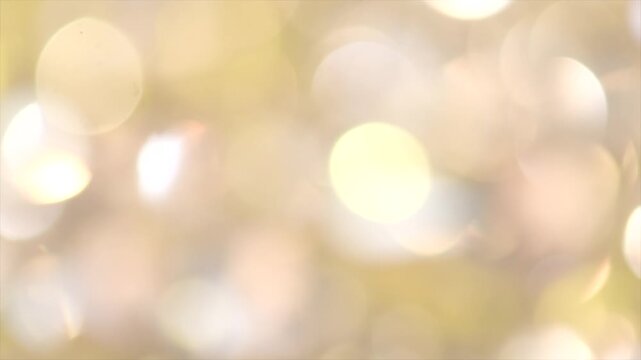 Holiday gold bokeh background. Glitter golden blurred sparkles background. Gold Glitter Blur Dust abstract backdrop. Christmas golden light shine particles. Holiday concept. Slow motion 