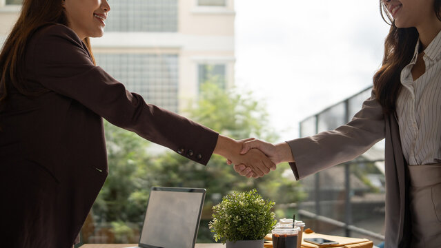 Close up of two businesswomen shaking hands to finalize a successful deal in a modern office