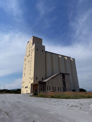 Abandoned industrial building under blue sky in rural landscape