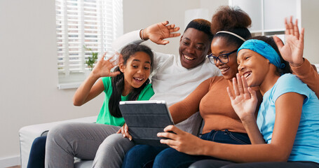 The family enjoys a peaceful moment on the couch of their new flat. A daughter picks furniture for her room while her parents and sister admire her choices.