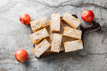 Applesauce cake with warm spices like cloves, ginger, and cinnamon close-up on a wooden board on a table. Horizontal top view from above