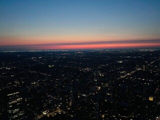 Aerial wide shot of Toronto city lights at night with sunset horizon