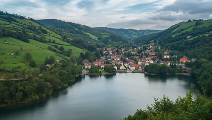 Fototapeta premium Idyllic lakeside view of a quaint town amidst green hills