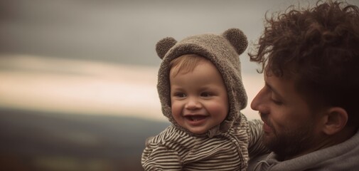 The Baby Smiling in a Bear Hoodie Held by Loving Father at Dusk