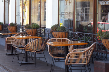 Outdoor Café Chairs and Tables. Empty outdoor café terrace with rattan chairs and tables, urban lifestyle background.
