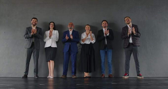 Applause of business team, happy professionals clapping hands, standing in row by office wall. Corporate employees applaud group unity and teamwork, success strategy and goal achievement on meeting
