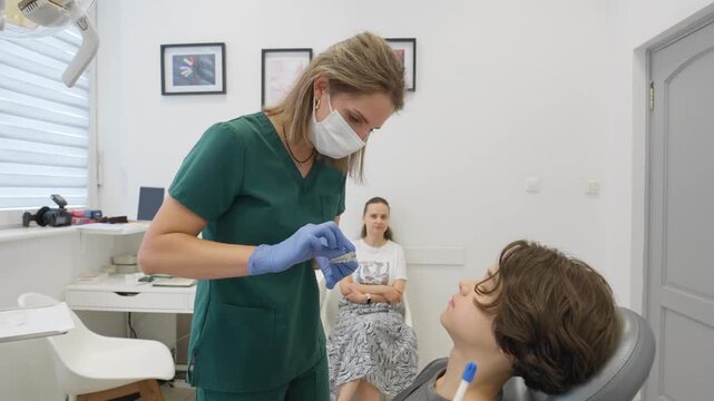 A doctor explains how to use a removable orthodontic trainer to a teenage boy. This myofunctional appliance is used for bite correction and to treat the causes of crooked teeth at night.