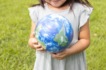 地球儀を持って草原で立っている女の子（5歳、日本人、顔無し）