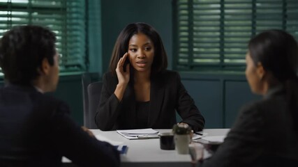 Three individuals engrossed in discussion at an office meeting.
