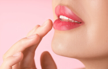 Obraz premium Woman with beautiful lipstick on her lips against pink background, macro view