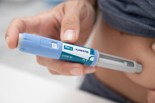 Person injecting Ozempic for diabetes and weight loss treatment