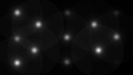 Black background with overlapping bright white light flares glow bokeh