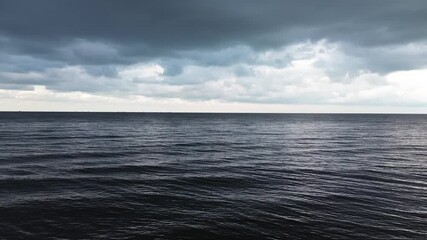 Aerial view of dark weather over the sea. Dark storm clouds on the surface of calm and peaceful sea water. The clouds are about to rain. - Powered by Adobe