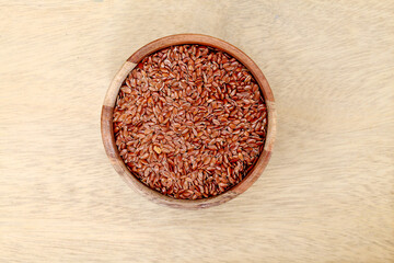 Bowl of flax seeds on wooden background