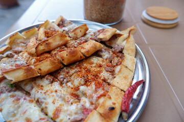 Meat and cheese pide from Tire, Izmir, Turkish cuisine, traditional dish known as ' kuşbaşılı kaşarlı pide'