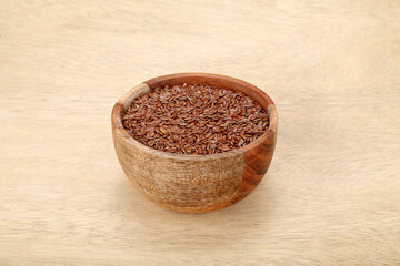 Bowl of flax seeds on wooden background