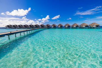 Panoramic landscape of Maldives beach. Tropical sunny panorama, luxury water villa sea sky. Resort wooden pier jetty. Luxury popular travel destination background summer holiday. Best vacation tourism