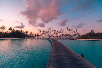 Amazing sunset panorama at Maldives. Luxury resort villas seascape with soft led lights under...