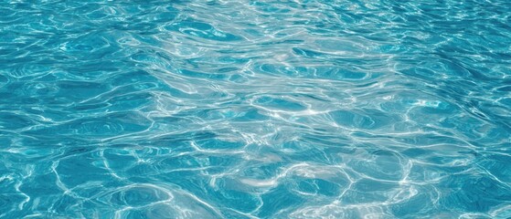 Obraz premium The shimmering surface of clear blue water in a tranquil setting.