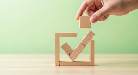 Hand Placing Final Wooden Block Forming a Check Mark Inside a Square &mdash; Symbolizing Approval, Success, and Quality Assurance