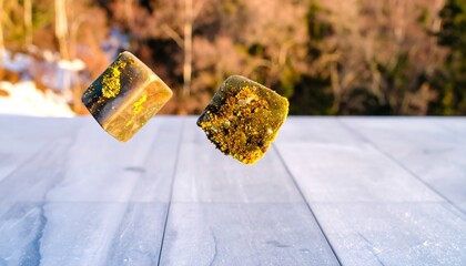 Two Levitating Squares with Yellow and Green Details on a Wooden Surface