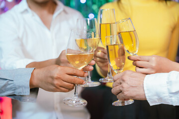 Group of friends clinking glasses of champagne together at a festive party, celebrating happiness and friendship with joyful smiles.