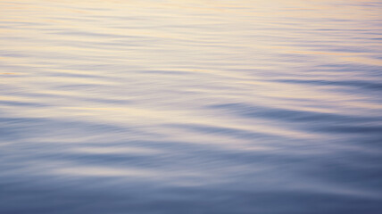 Soft water surf natural minimal background abstract calm ocean reflection at sunset with gentle ripples and pastel colors