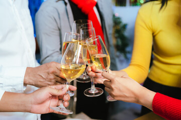 Group of friends clinking glasses of champagne together at a festive party, celebrating happiness and friendship with joyful smiles.