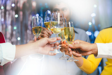 Group of friends clinking glasses of champagne together at a festive party, celebrating happiness and friendship with joyful smiles.