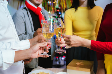 Group of friends clinking glasses of champagne together at a festive party, celebrating happiness and friendship with joyful smiles.