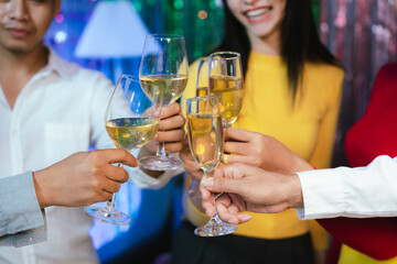 Group of friends wearing Santa hats raising glasses of champagne, celebrating Christmas or New Year together with joy and smiles.