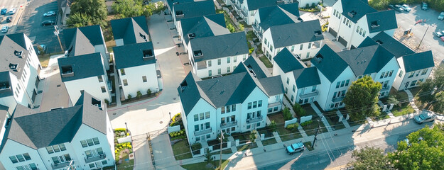 Panorama aerial view modern white townhomes in gated community near Main Street and Abram, Cooper at downtown Arlington, Texas. Courtyard-style layout, sidewalks, and tree buffers walkability