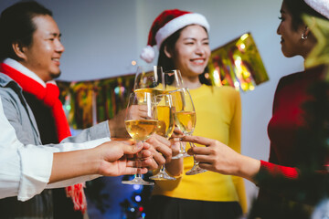 Group of friends wearing Santa hats raising glasses of champagne, celebrating Christmas or New Year together with joy and smiles.