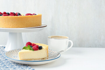Delicious cheesecake with fresh berries and mint served on white table, space for text