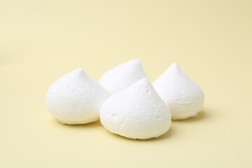 Yummy meringue cookies on beige background, closeup