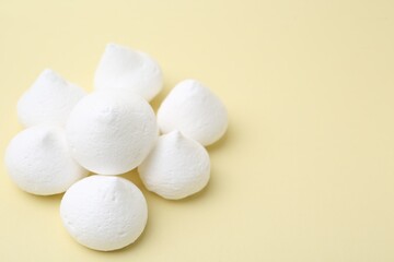Yummy meringue cookies on beige background, closeup. Space for text