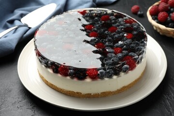 Delicious cheesecake with berries served on black textured table, closeup