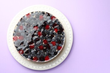 Delicious cheesecake with berries on violet background, top view. Space for text