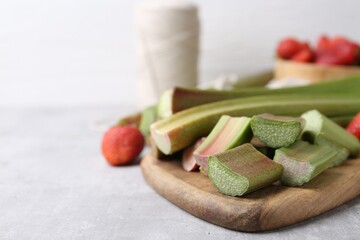 Cut fresh rhubarb and strawberries on light table, closeup. Space for text