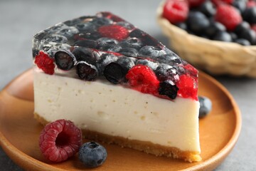 Piece of delicious cheesecake with berries on grey table, closeup